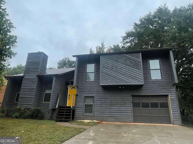 view of front of house with a garage and a front lawn