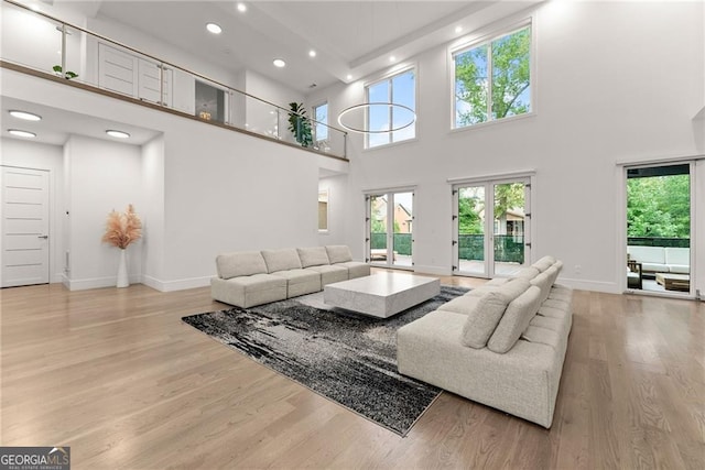 living room featuring light hardwood / wood-style flooring and a high ceiling