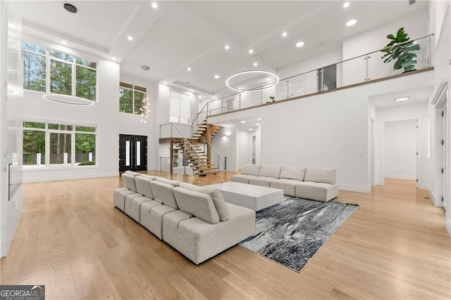 living room with a high ceiling and light hardwood / wood-style floors