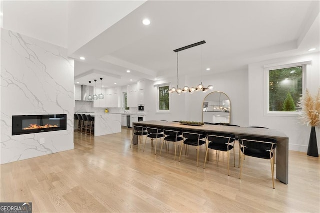 dining space featuring a high end fireplace and light hardwood / wood-style flooring