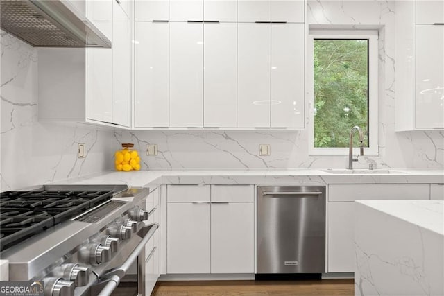 kitchen featuring white cabinetry, sink, wall chimney range hood, and stainless steel appliances