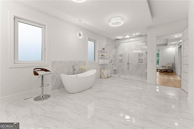 bathroom with a wealth of natural light and independent shower and bath