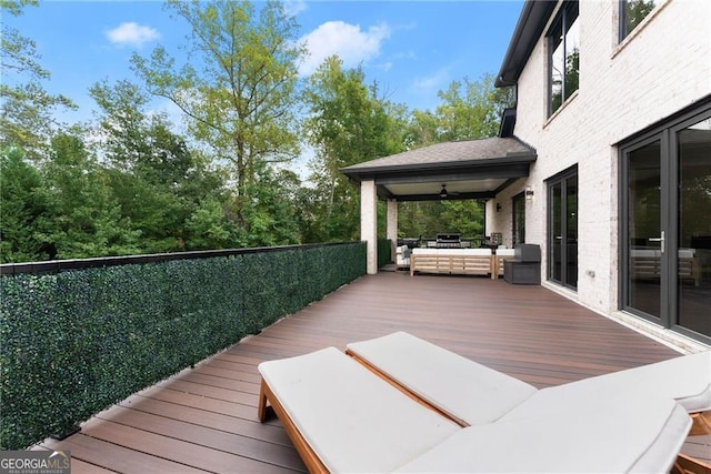 deck with ceiling fan and an outdoor living space