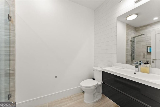 bathroom featuring wood-type flooring, an enclosed shower, vanity, and toilet