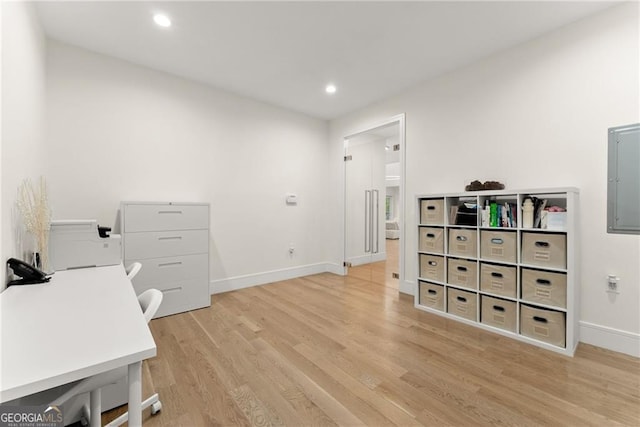 office area with light hardwood / wood-style floors and electric panel