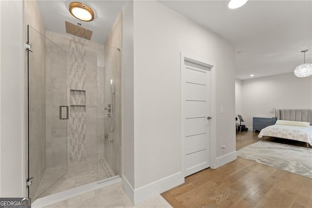 bathroom with hardwood / wood-style flooring and an enclosed shower