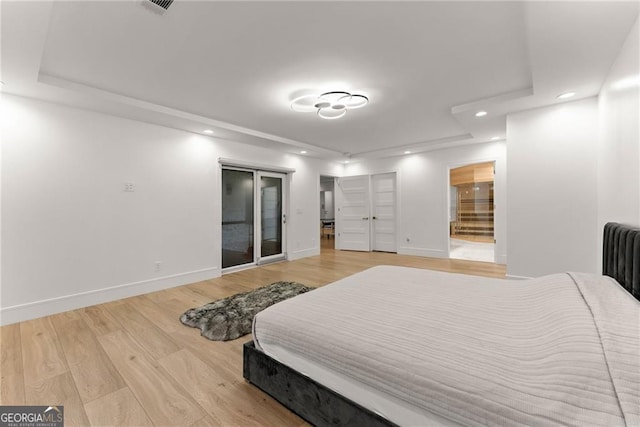 bedroom with hardwood / wood-style flooring and ensuite bath