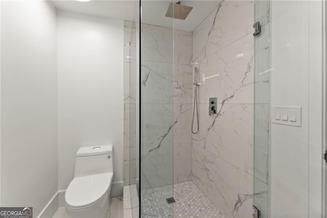 bathroom with a shower with shower door and toilet