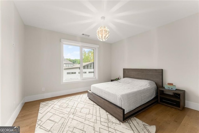 bedroom featuring light hardwood / wood-style flooring and a notable chandelier