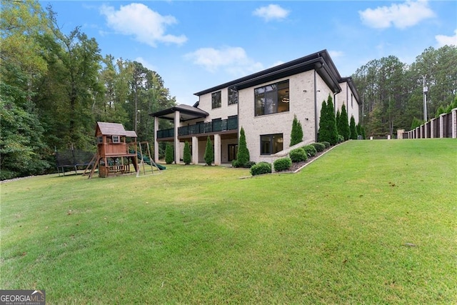 back of house with a playground and a yard