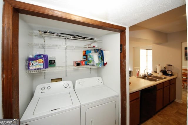 washroom with sink, dark wood-type flooring, washing machine and dryer, and a textured ceiling