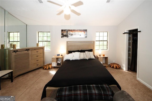 bedroom with vaulted ceiling, light colored carpet, a barn door, and ceiling fan