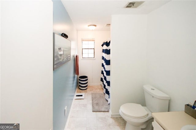 bathroom featuring vanity, walk in shower, toilet, and tile patterned floors