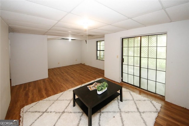 living room featuring hardwood / wood-style floors and a paneled ceiling