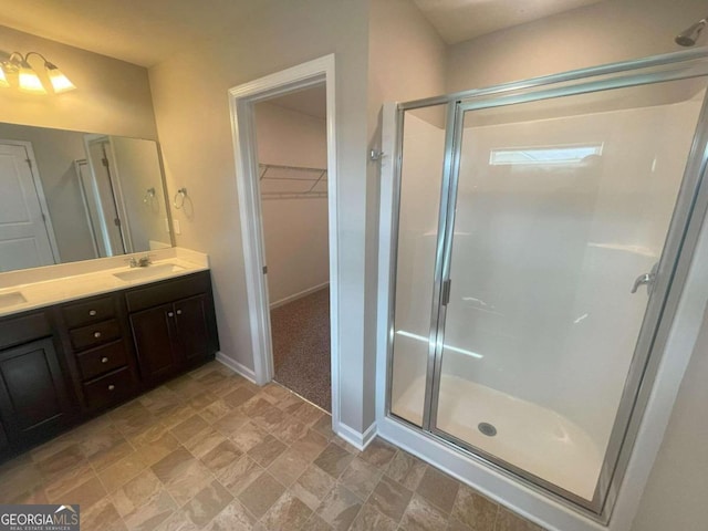 bathroom with a shower with shower door and vanity