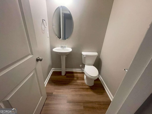 bathroom with wood-type flooring and toilet