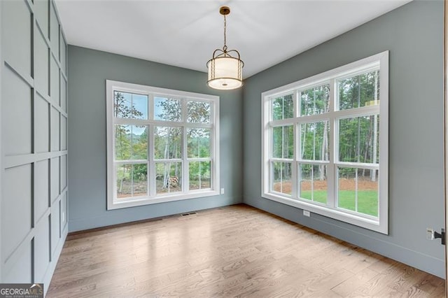 unfurnished dining area with light wood-type flooring and a wealth of natural light