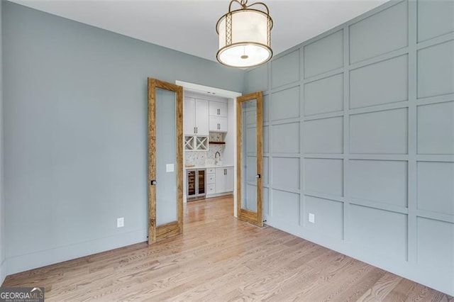 interior space with beverage cooler and light hardwood / wood-style flooring