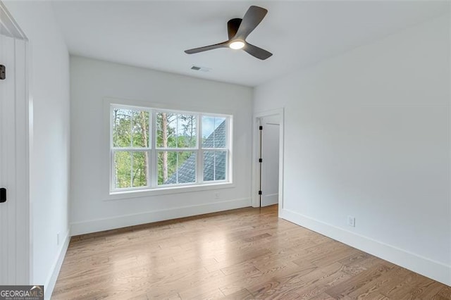 spare room with light wood-type flooring and ceiling fan