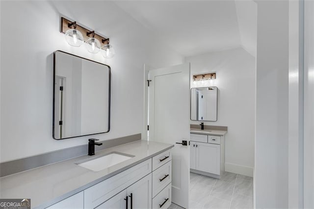 bathroom featuring vanity and lofted ceiling