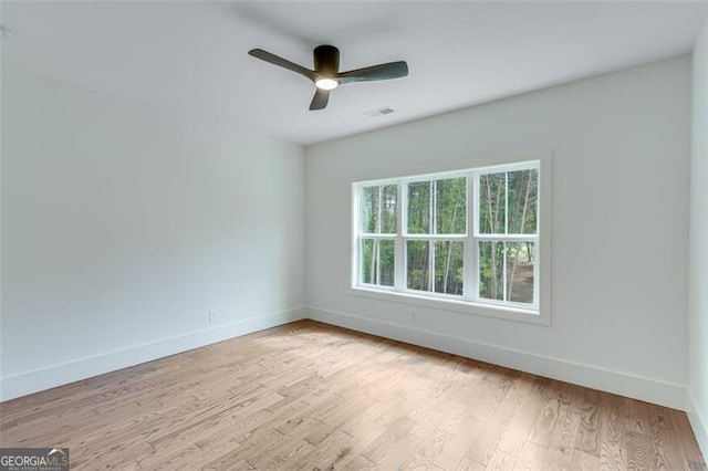 spare room with light wood-type flooring and ceiling fan