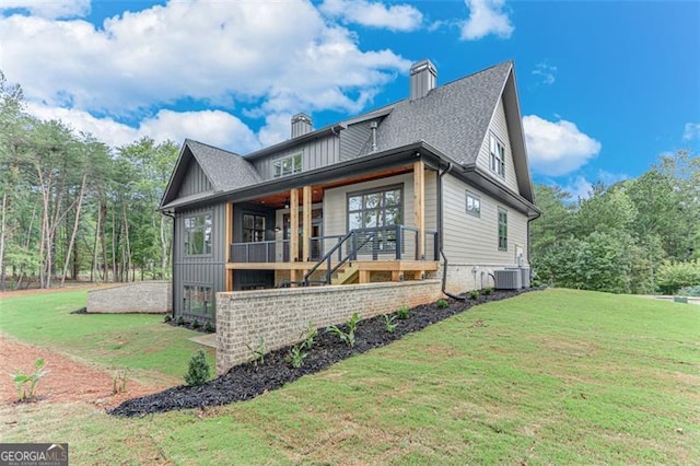 view of front of property with a front lawn and central air condition unit