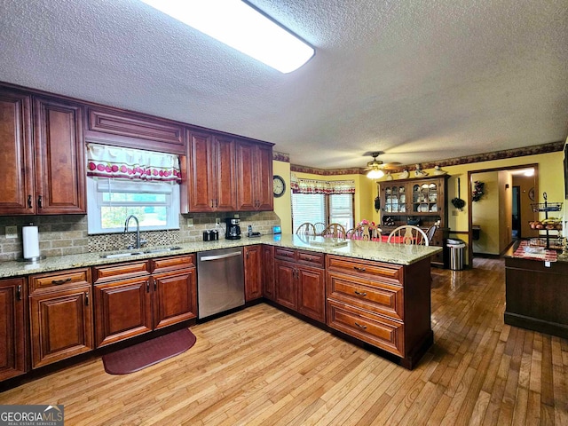 kitchen featuring kitchen peninsula, dishwasher, light hardwood / wood-style flooring, and sink