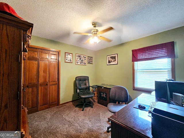 home office with ceiling fan, carpet floors, and a textured ceiling