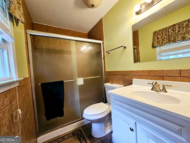 bathroom featuring tile walls, an enclosed shower, vanity, and toilet