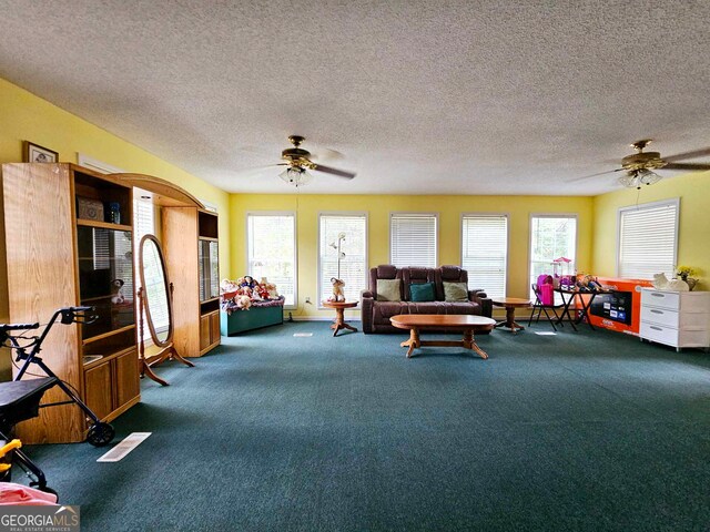 interior space featuring a textured ceiling, carpet flooring, and ceiling fan