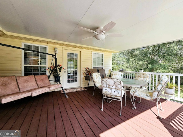 wooden terrace with ceiling fan and an outdoor hangout area