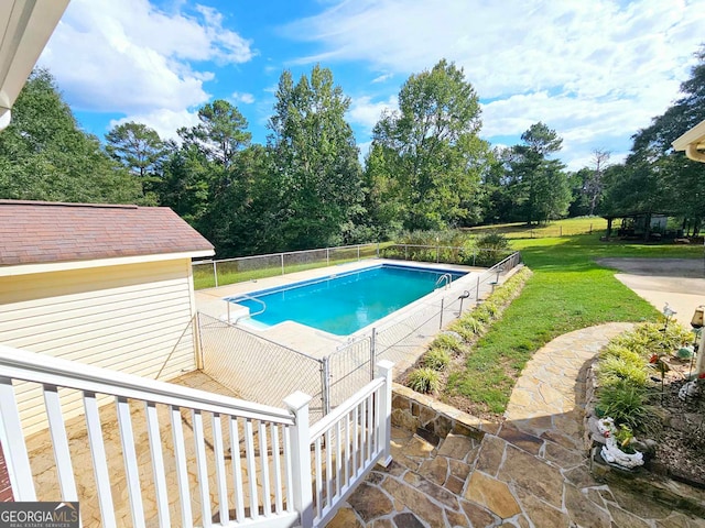 view of swimming pool featuring a patio and a yard