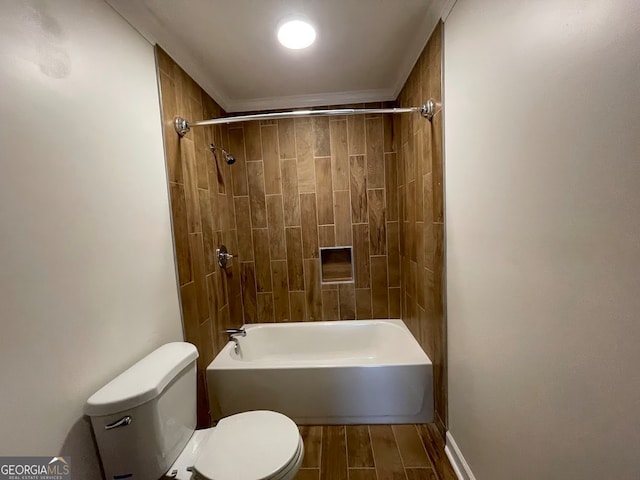 bathroom featuring tiled shower / bath combo, hardwood / wood-style floors, and toilet