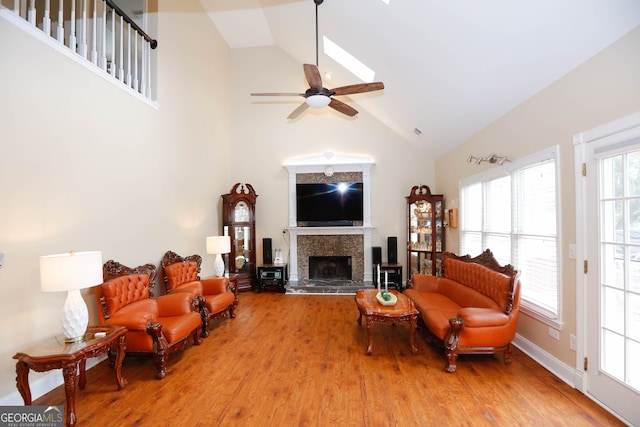 living room with ceiling fan, light wood-type flooring, and high vaulted ceiling