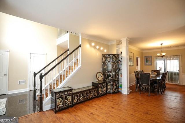 interior space featuring ornamental molding, decorative columns, and hardwood / wood-style floors