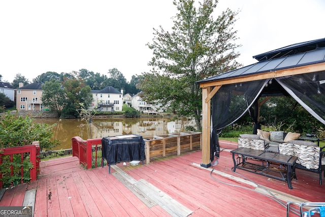 wooden deck featuring a water view, area for grilling, and a gazebo