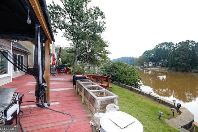 wooden terrace with a lawn and a water view