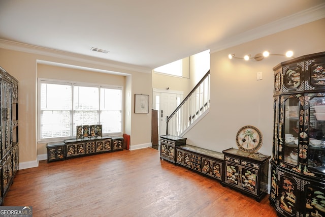 entrance foyer with ornamental molding and hardwood / wood-style floors