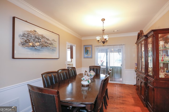 dining room with ornamental molding, a chandelier, and hardwood / wood-style floors