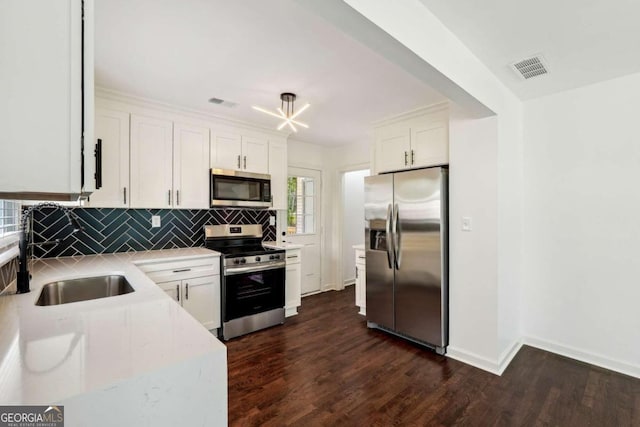 kitchen featuring white cabinets, sink, tasteful backsplash, appliances with stainless steel finishes, and dark hardwood / wood-style floors