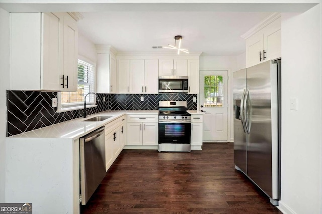 kitchen featuring tasteful backsplash, dark wood-type flooring, sink, white cabinetry, and appliances with stainless steel finishes