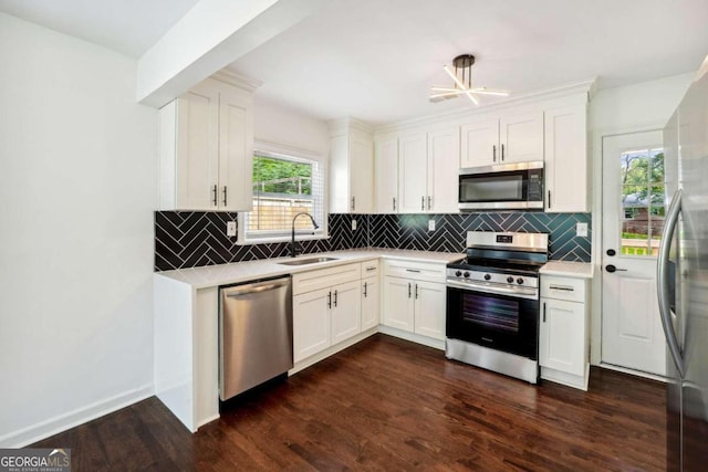 kitchen featuring appliances with stainless steel finishes, dark wood-type flooring, sink, and white cabinetry