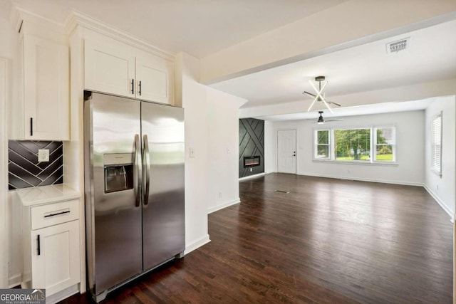 kitchen featuring ceiling fan, white cabinets, stainless steel fridge, and decorative backsplash