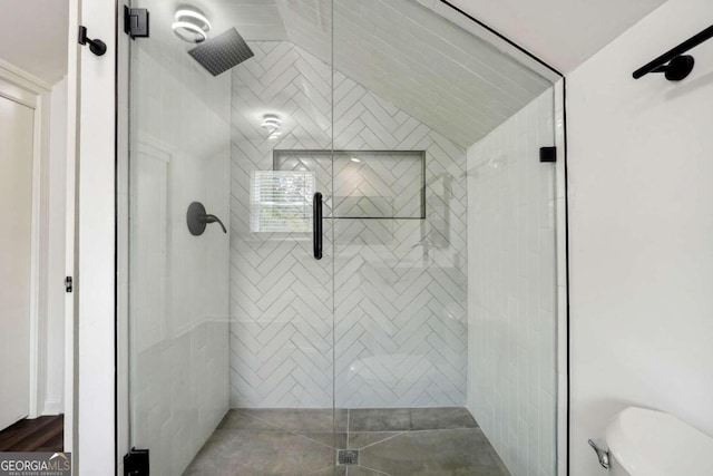 bathroom with lofted ceiling, toilet, tile patterned flooring, and an enclosed shower