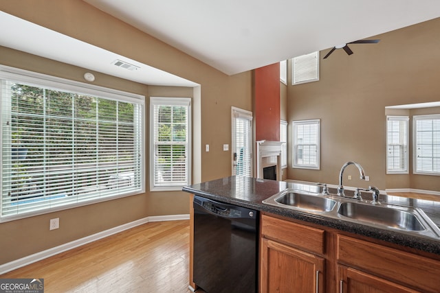 kitchen with light wood-type flooring, black dishwasher, sink, and ceiling fan