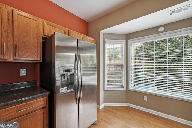 kitchen with stainless steel fridge and light hardwood / wood-style floors