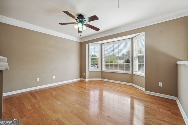 unfurnished room with ceiling fan, light wood-type flooring, and crown molding