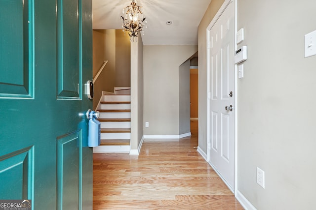 entrance foyer with light hardwood / wood-style flooring and a notable chandelier