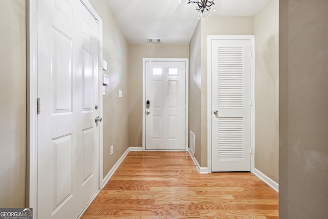 entryway with light hardwood / wood-style flooring and a chandelier