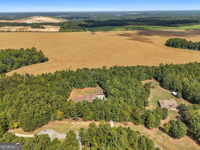 aerial view featuring a wooded view and a rural view